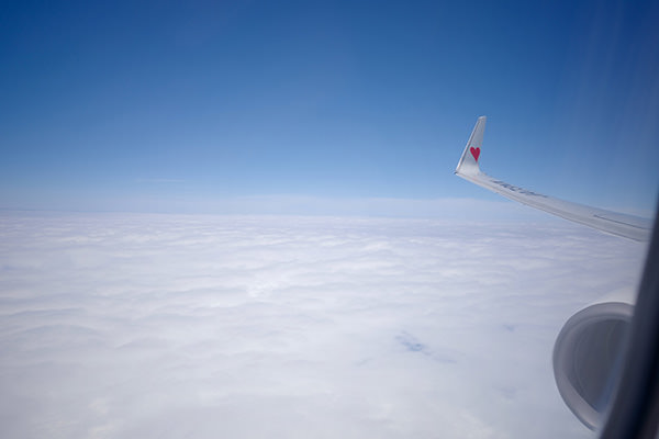 青空と雲海が広がる機窓